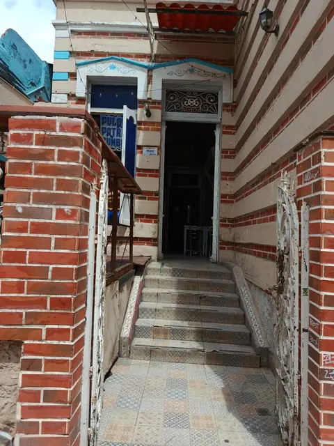 Escalera de entrada entre muros de ladrillo a rayas